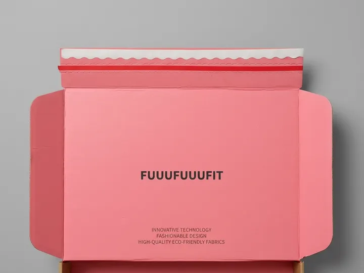 Pink printed inner lid of a custom apparel mailer box with white sealing strip and wave perforation