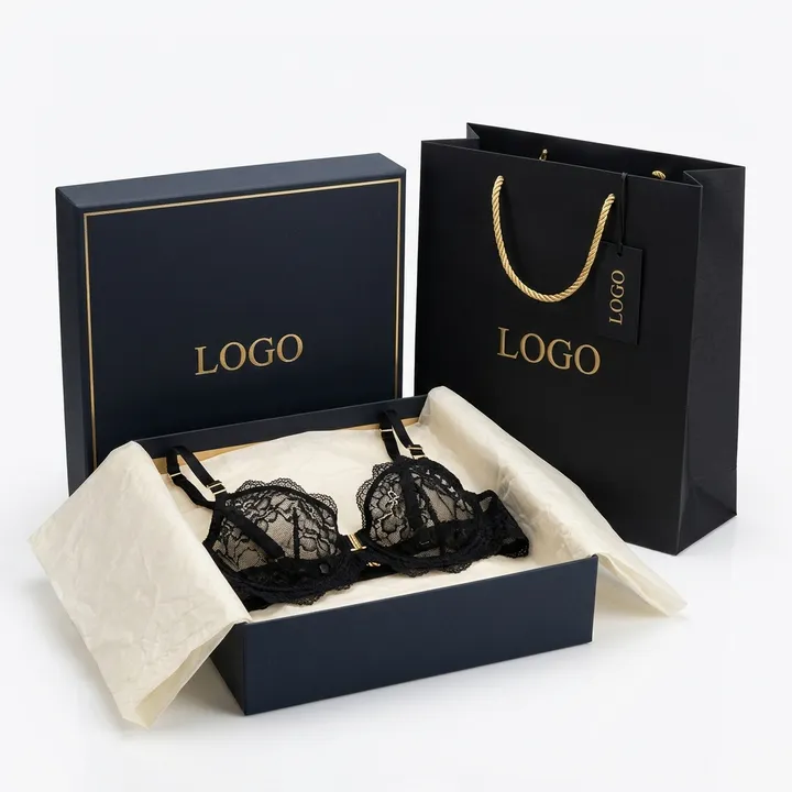 Black lace bra protected by tissue paper in an open navy rigid lingerie box with shopping bag