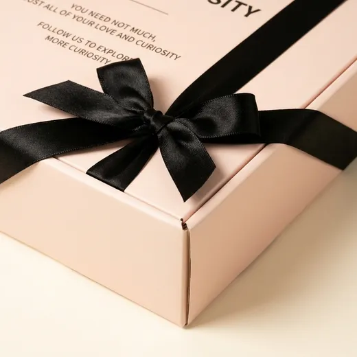 Four centimetre black satin ribbon bow detail on a pale pink fold-over bra gift box