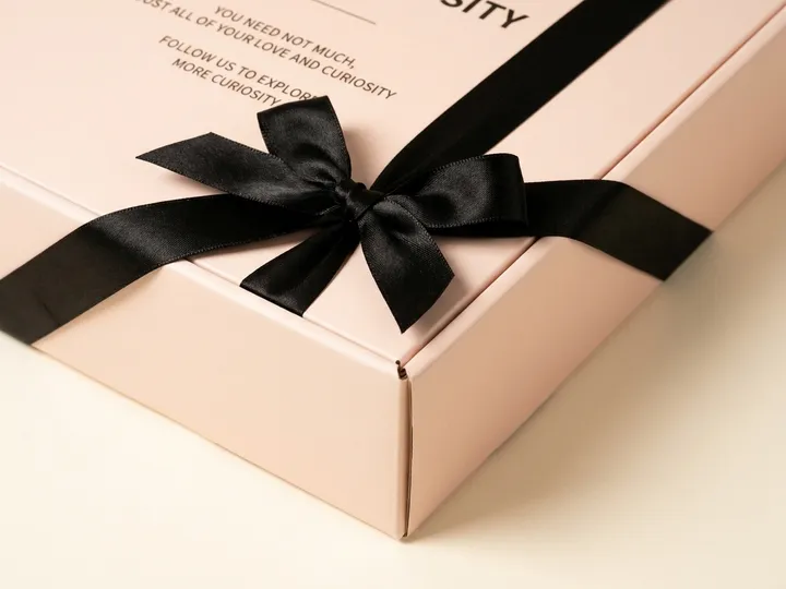 Four centimetre black satin ribbon bow detail on a pale pink fold-over bra gift box