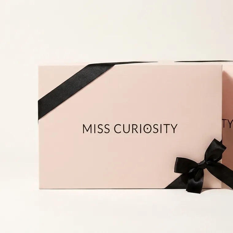 Two pale pink custom bra gift boxes with black satin ribbon bows