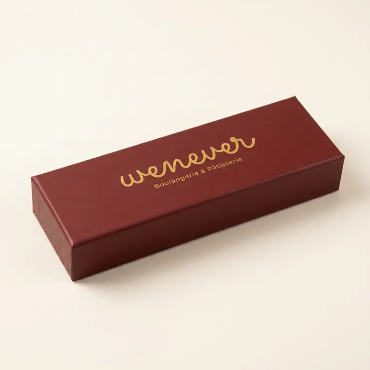 Closed long burgundy two-piece chocolate box with gold English foil artwork