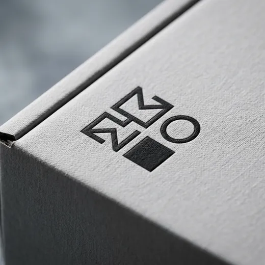 Macro view of black logo printing on the textured gray surface of a perfume mailer box