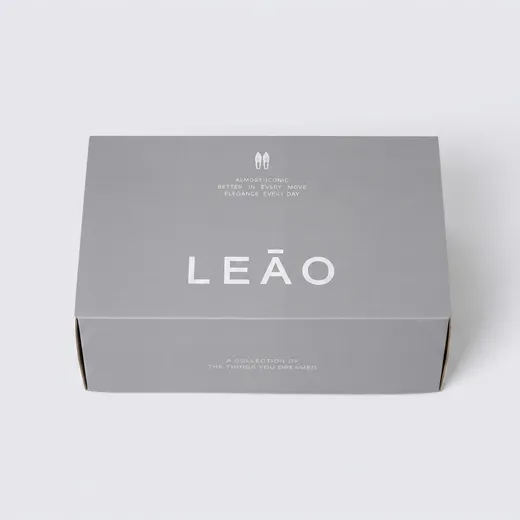 Front studio view of a closed gray corrugated shoe box with silver foil branding