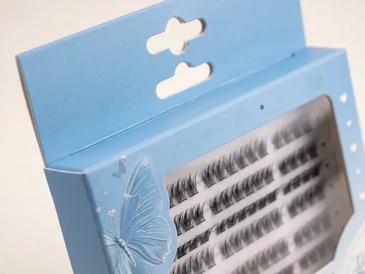 Close-up of two retail hanging slots above the clear PET window on an eyelash carton