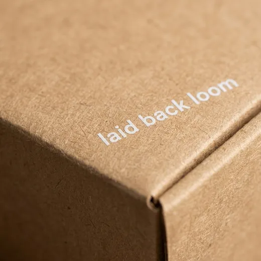Close-up of white printed lettering on the natural kraft belt box lid