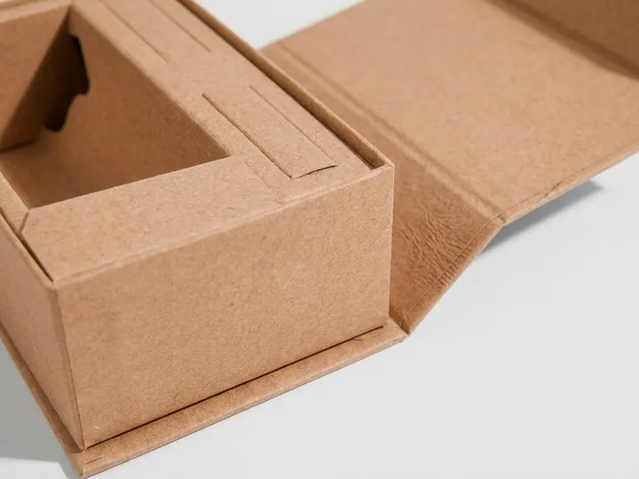 Close-up of wrapped spine and fixed tray wall on an open kraft rigid box