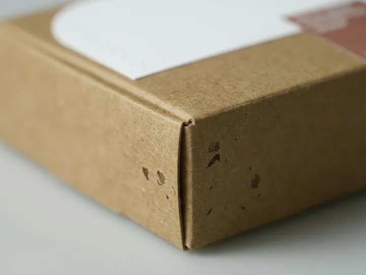Macro view of natural kraft paper fibers and a folded carton edge