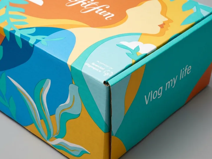 Close view of full-color subscription mailer artwork crossing a folded corner and lid edge