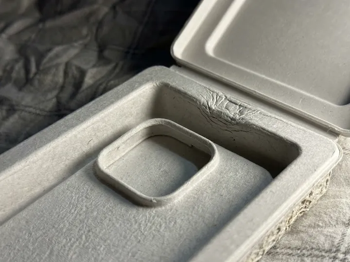 Close-up of molded pulp phone case cavity, rim, and hinge transition
