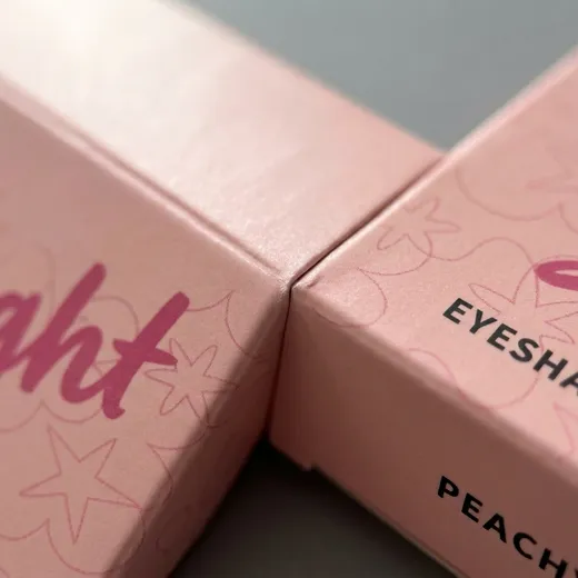 Macro view of pink CMYK artwork and matte lamination across a folded carton edge