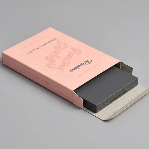 Closed makeup palette sliding into a shallow pink folding carton without an insert