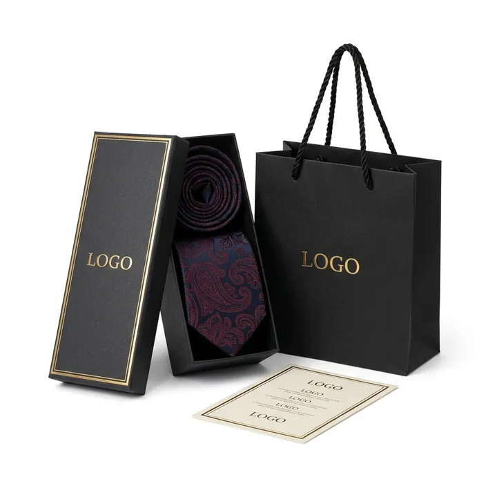 Patterned silk necktie arranged in an open slim black tie box with matching shopping bag