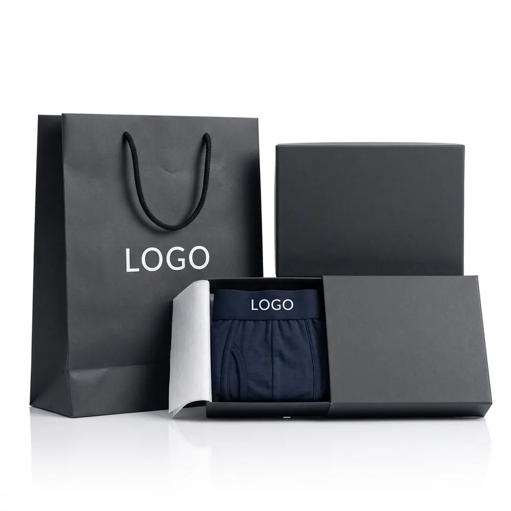 Folded navy underwear in an open black retail box beside a matching shopping bag