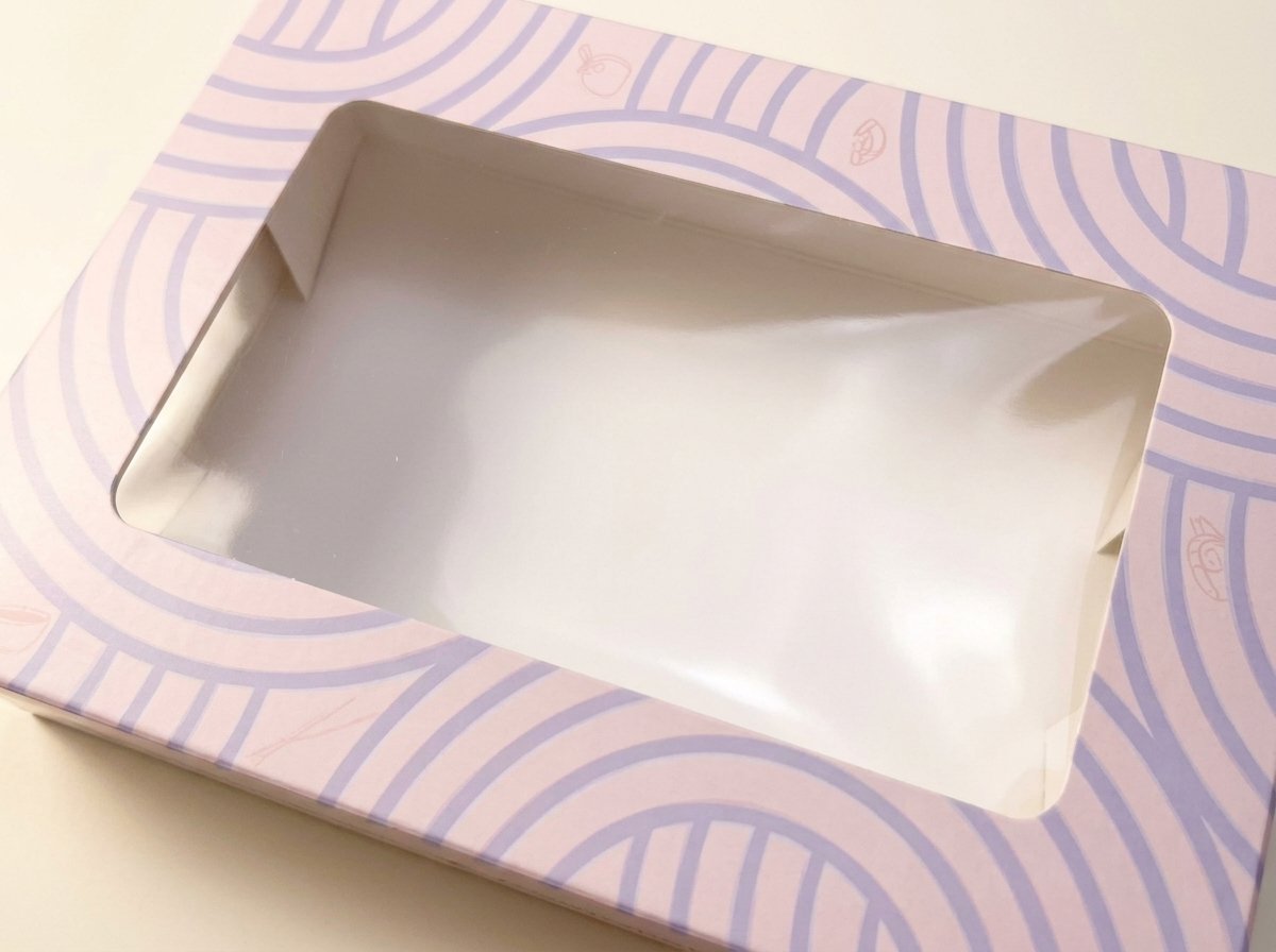 Clear window film and pale pink printed border on a custom bakery carton